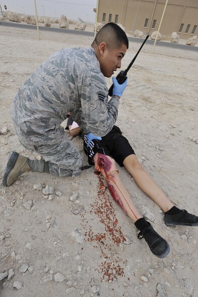 Senior Airman Marco Melendez, 379th Expeditionary Medical Operations Squadron, Al Udeid Air Base, Qatar, radios commands to another responder during a mass casualty exercise at AUAB, Dec. 15. The exercise tested the emergency response capabilities of fire and medical personnel. (U.S. Air Force photo by Master Sgt. Joshua Strang)