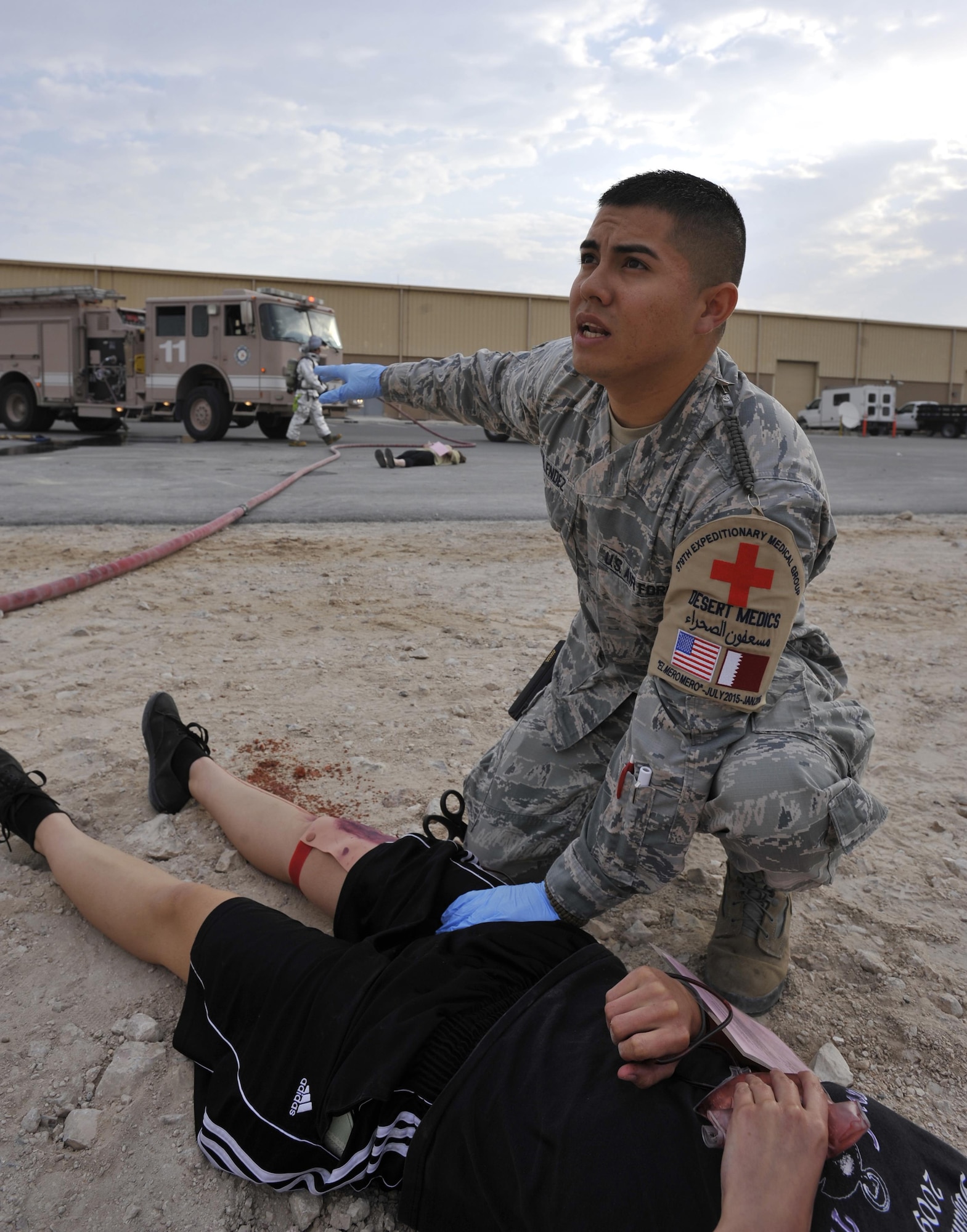 Senior Airman Marco Melendez, 379th Expeditionary Medical Operations Squadron, Al Udeid Air Base, Qatar, yells commands to another responder during a mass casualty exercise at AUAB, Dec. 15. The exercise tested the emergency response capabilities of fire and medical personnel. (U.S. Air Force photo by Master Sgt. Joshua Strang)
