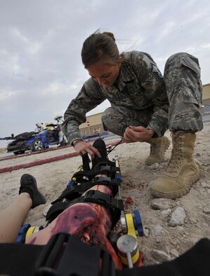 Master Sgt. Shanna Bufkin, medical technician, 340th Expeditionary Air Refueling Squadron, Al Udeid Air Base, Qatar, attends to a patient during a mass casualty exercise at AUAB Dec. 15, 2015. The exercise tested the emergency response capabilities of fire and medical personnel. (U.S. Air Force photo by Master Sgt. Joshua Strang)