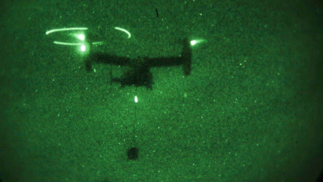 An MV-22B Osprey, operated by a crew with Marine Medium Tiltrotor Training Squadron 204, carries cargo during a night time external lifts operation at Marine Corps Base Camp Lejeune, N.C., Dec. 14, 2015. Marines with 2nd Transportation Support Battalion supported the exercise to facilitate the required flight hours for  student pilots, and practice their own skills as a helicopter support team securing transportation of resources for Marines that would need it in a real-world operation.