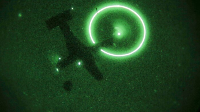An MV-22B Osprey, operated by a crew with Marine Medium Tiltrotor Training Squadron 204, carries cargo during a night time external lifts operation at Marine Corps Base Camp Lejeune, N.C., Dec. 14, 2015. Marines with 2nd TSB supported the exercise to facilitate the required flight hours for student pilots, and practice their own skills as a helicopter support team securing transportation of resources for Marines that would need it in a real-world operation. 