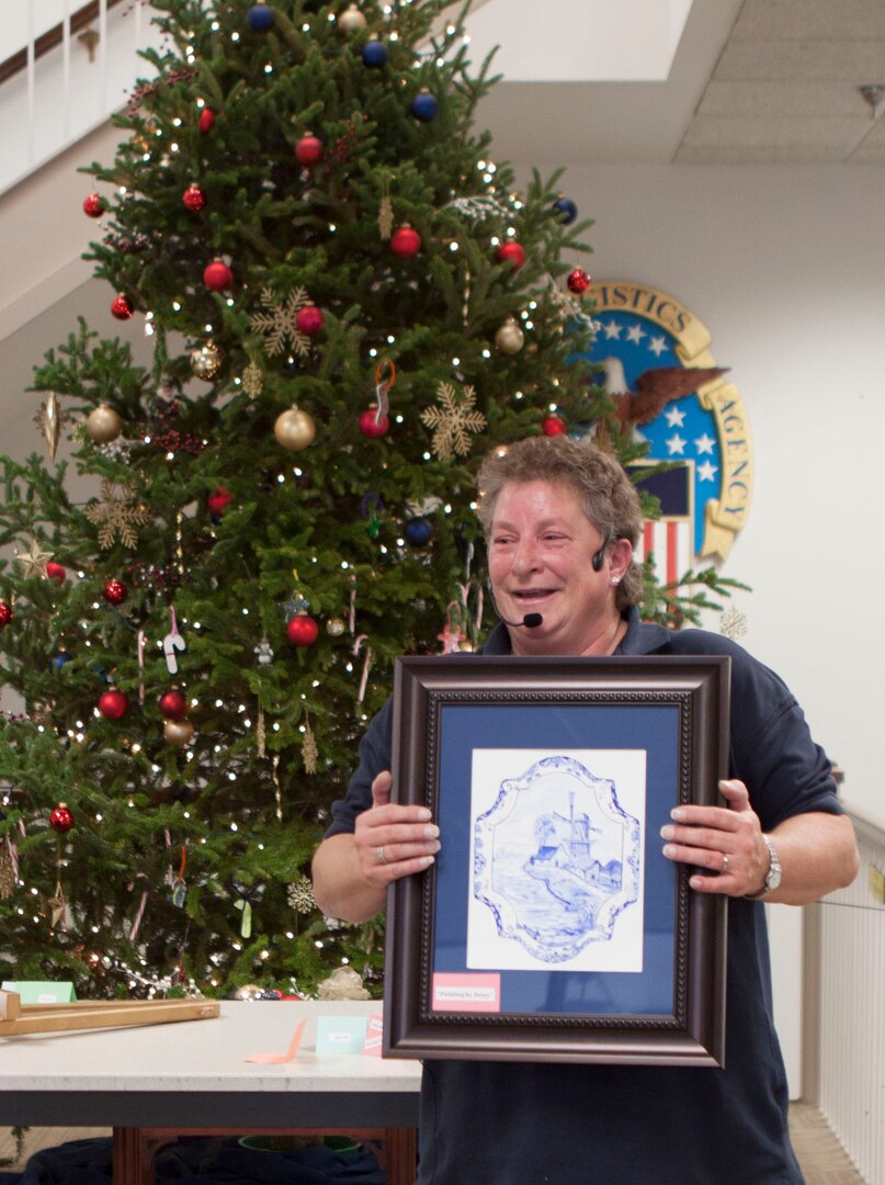 Wendy Evans, Future Operations and auctioneer, auctions off a watercolor painting by Distributions own Chief Integration Officer, Perry Knight, during the noisy auction benefiting the CFC on Dec. 11.