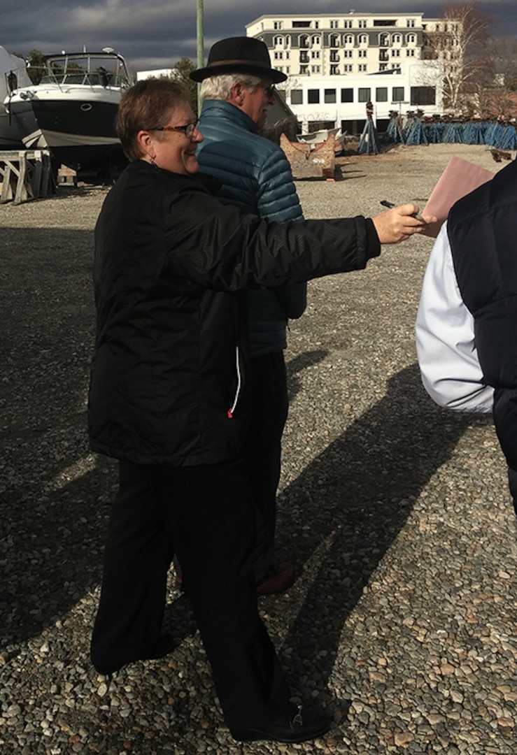 City of Groton Mayor Marian Galbreath signs for two watercraft recently acquired through DLA Disposition Services. The utility craft are expected to ferry up to 350,000 visitors a year to sites along the Thames River in Connecticut.