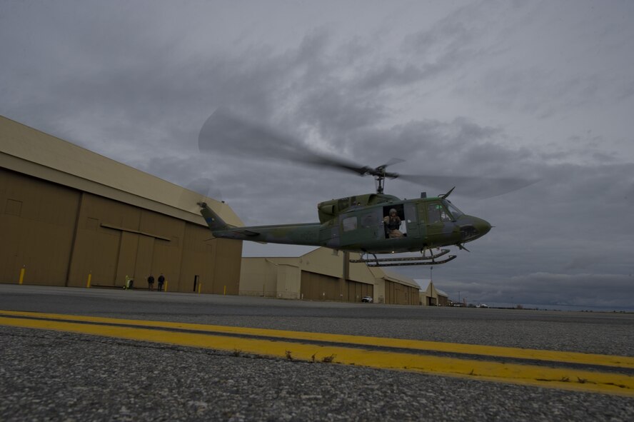 A UH-1N Iroquois helicopter hovers above the runway Nov. 9, 2015, at Fairchild Air Force Base, Wash. The 36th Rescue Squadron supports the Survival School with numerous platforms. They provide parachute operations, hoist and vector training, and perform civilian search and rescue with 689 saves to date. (U.S. Air Force photo/Airman 1st Class Nick J. Daniello)