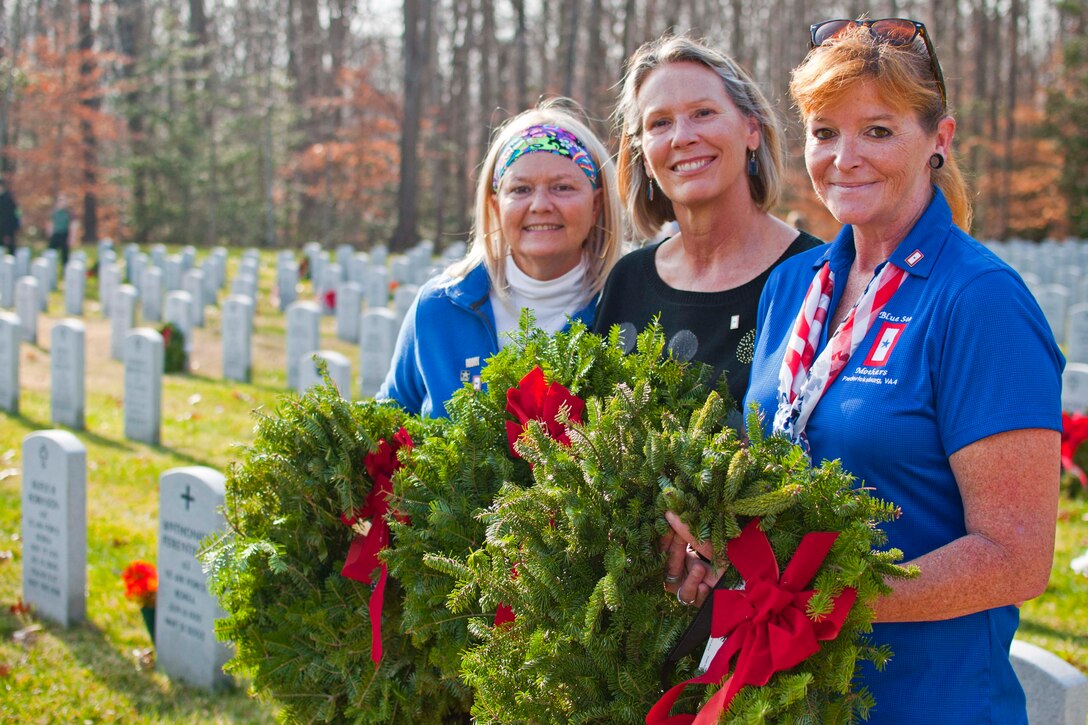 Teri Reece, Blue Star Mothers president, Rhonda Kuebler, Blue Star Mothers member, and Sharon Kendall, Blue Star Mothers member, participate in the annual Wreaths Across America Dec. 12 at Quantico Netional Cemetery in Triangle, Virginia. After seven years, the group continues to support veterans and their families at this annual Wreaths Across America event. In addition to the wreaths, the members raised funds to send approximately 400 care packages to deployed troops overseas during the holidays.