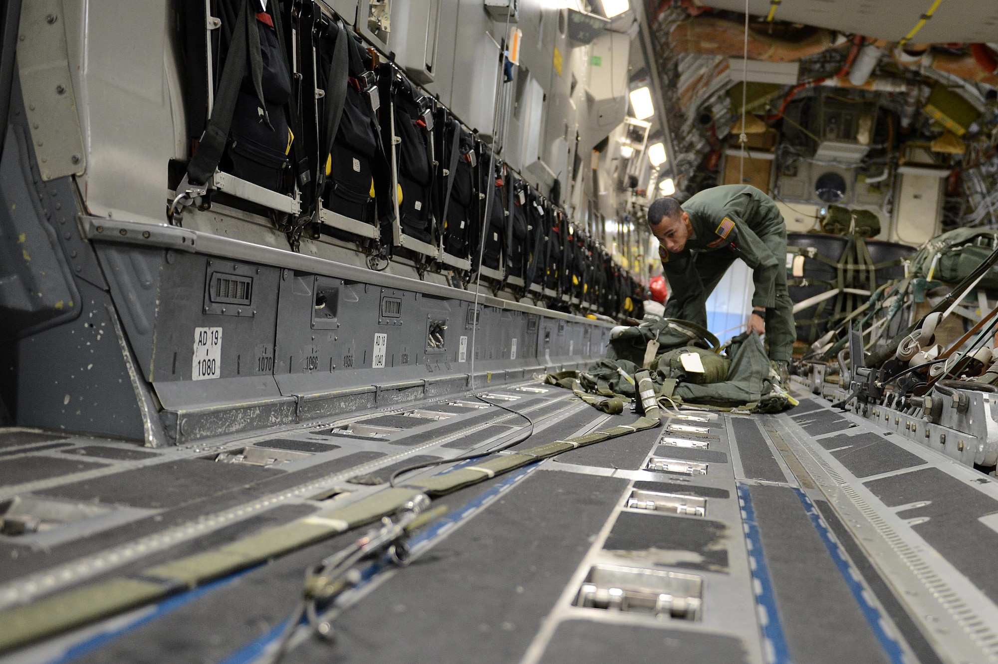 Staff Sgt. Joseph Timpson, a 10th Airlift Squadron loadmaster, checks over a parachute for an airdrop during exercise Rainier War Dec. 10, 2015, on the flightline at Joint Base Lewis-McChord, Wash. The parachute is used to pull the cargo out of the aircraft before another parachute opens up and safely drops the cargo on the drop zone. (U.S. Air Force photo/Senior Airman Divine Cox)