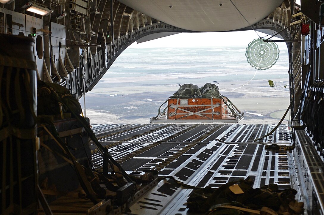 A heavy container delivery system cargo drops out the back of a C-17 Globemaster III during the exercise Rainier War Dec. 10, 2015, over the Rainier drop zone in Washington. The aircrew dropped multiple loads of cargo onto the DZ in support of the large formation exercise. (U.S. Air Force photo/Senior Airman Divine Cox)