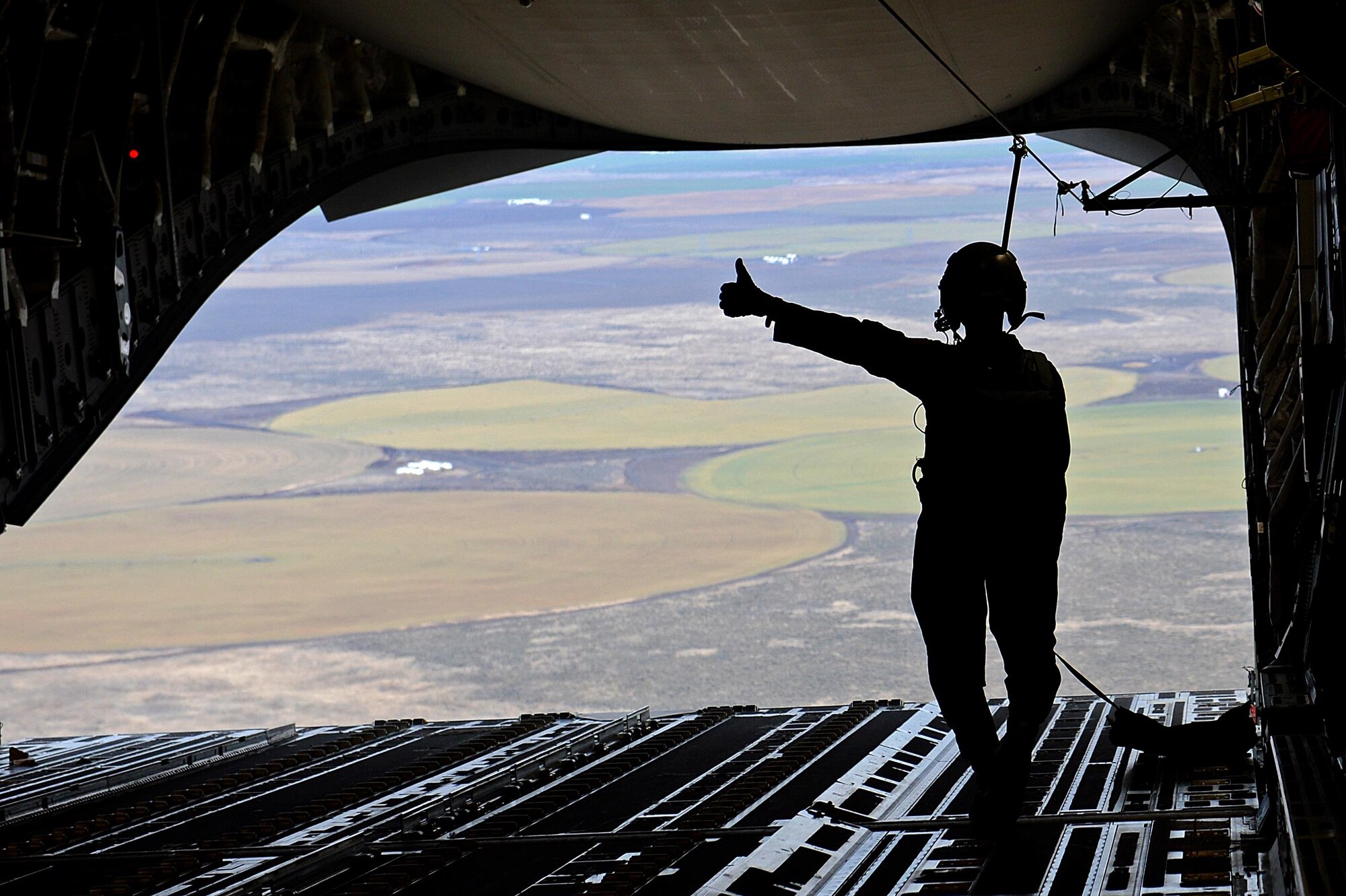 Staff Sgt. Joseph Timpson, a 10th Airlift Squadron loadmaster, gives a thumbs up after an airdrop during exercise Rainier War Dec. 10, 2015, over the Rainier drop zone in Washington. Rainier War included the large formation airdrops and a larger formation of C-17 Globemaster IIIs before heading back to Joint Base Lewis-McChord, Wash. (U.S. Air Force photo/Senior Airman Divine Cox)