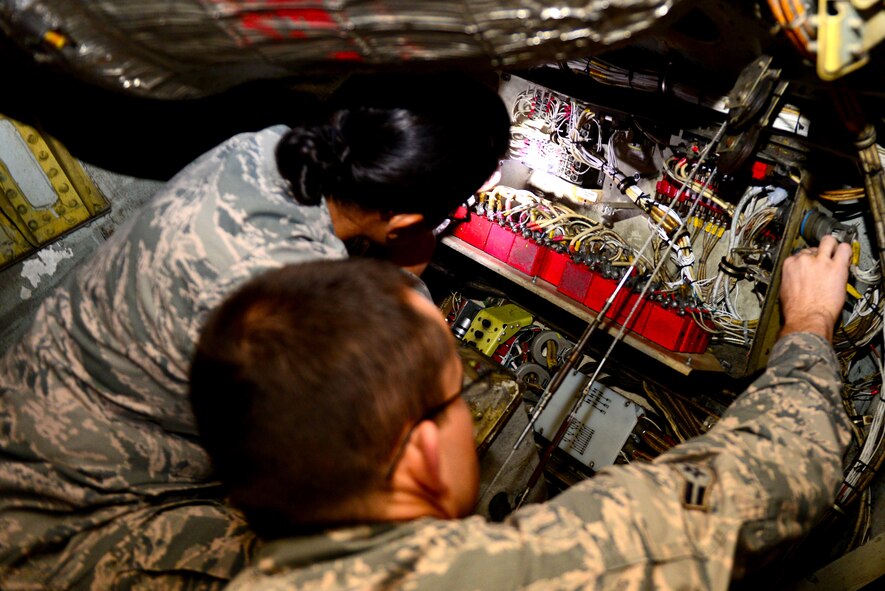 Airmen 1st Class Gillan Bagapuro, left, and Daniel Stevens, make repairs to a power box on a B-52 Stratofortress at Barksdale Air Force Base, La., Dec. 15, 2015. Bagapuro and Stevens inspected the power box for corrosive wiring and loose connections, as well as making sure the box is wired correctly. (U.S. Air Force Photo/Airman 1st Class Luke Hill)