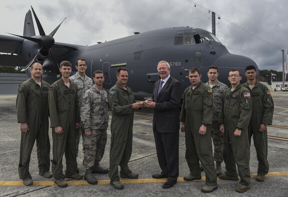 Col. Sean Farrell, commander of the 1st Special Operations Wing, receives a commemorative key to the MC-130J Commando II from Ray Fajay, director of air mobility business development at Lockheed Martin, at Lockheed Martin in Marietta, Ga., Dec. 11, 2015. The MC-130J will undergo modifications to become an AC-130J Ghostrider, which will provide the 1 SOW with close air support and air interdiction capabilities. (U.S. Air Force photo by Senior Airman Ryan Conroy)