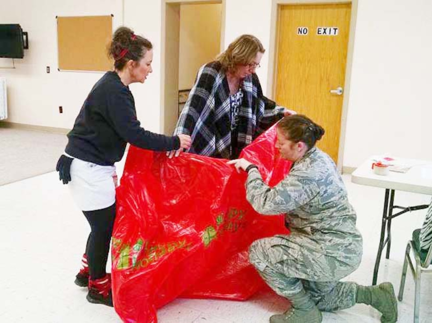 Defense Logistics Agency  Aviation employees Denise Buckley (right)  and Cathy Hopkins, along with Air Force Capt. Tiffany Sellers, bag a bicycle provided for a student receiving gifts from Bensley Elementary School’s annual Angel Tree program Dec. 16, 2015.  DLA employees at Defense Supply Center Richmond, Virginia, adopted and provided gifts for 112 students in need from four local schools.