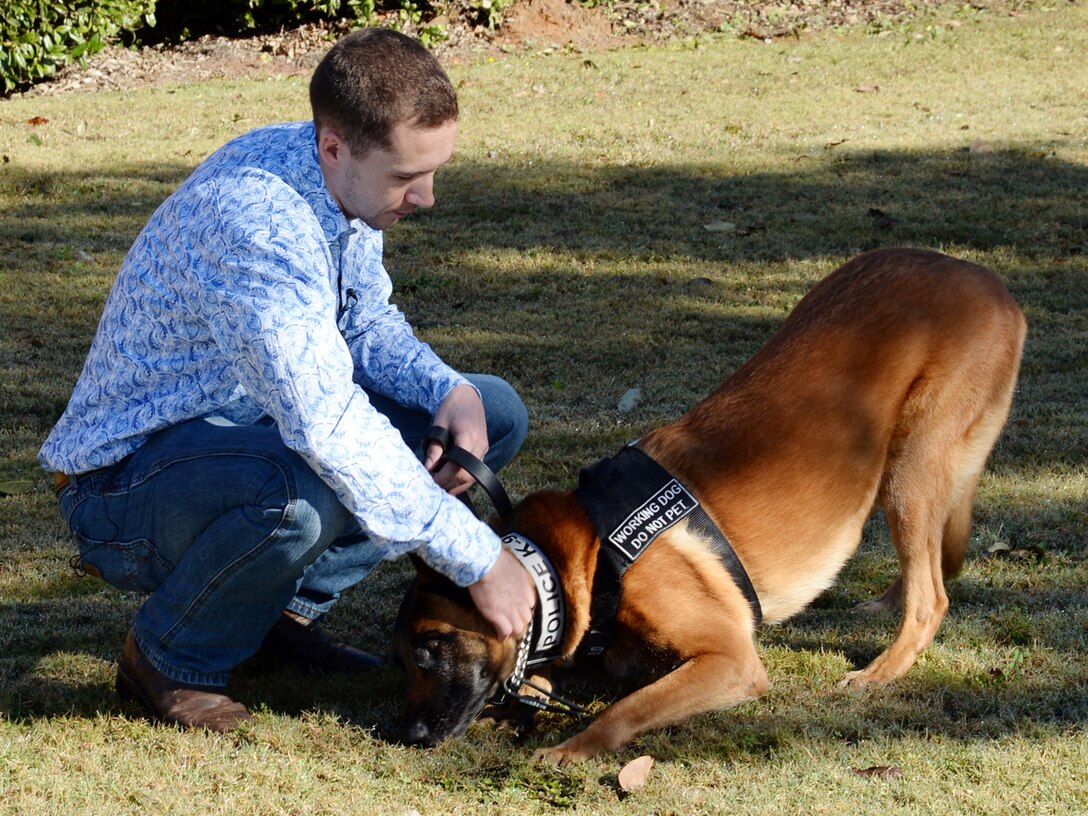 Former Marine Corps handler, David Pond, plays with Pablo, a former military working dog, Marine Corps Logistics Base Albany’s Marine Corps Police Department, after officially adopting him during a ceremony held here, Dec. 15.