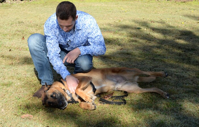 Former Marine Corps handler, David Pond, plays with Pablo, a former military working dog, with Marine Corps Logistics Base Albany’s Marine Corps Police Department, after officially adopting him during a ceremony held here, Dec. 15.