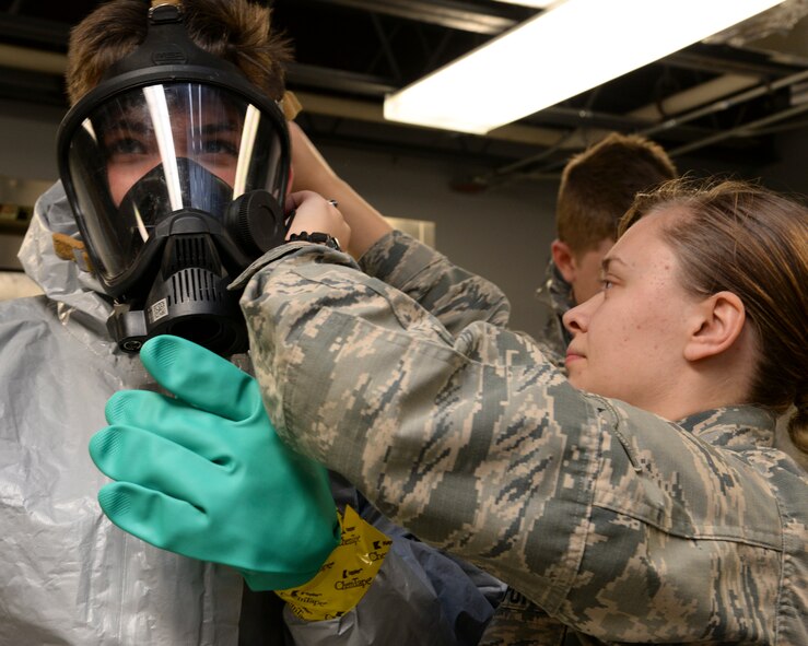 Airman Marissa Tucker, 2nd Civil Engineer Squadron emergency management apprentice, puts a fire-hawk mask on a Boy Scout during a chemical, biological, radiological and nuclear demonstration at Barksdale Air Force Base, La., Dec. 11, 2015. Fire-Hawk masks are used in environments where biological vapor hazards might be present. (U.S. Air Force photo/Senior Airman Jannelle Dickey)
