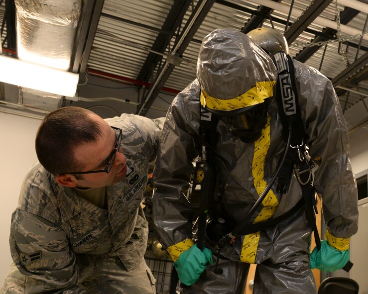 Airman First Class Jacob Buchanan, 2nd Civil Engineer Squadron emergency management journeyman, assists a Boy Scout with a level-B hazardous material suit at Barksdale Air Force Base, La., Dec. 11, 2015. The day long base tour provided the scouts with the opportunity to learn about various career fields and understand the mission and programs of the 2nd Bomb Wing. (U.S. Air Force photo/Senior Airman Jannelle Dickey)