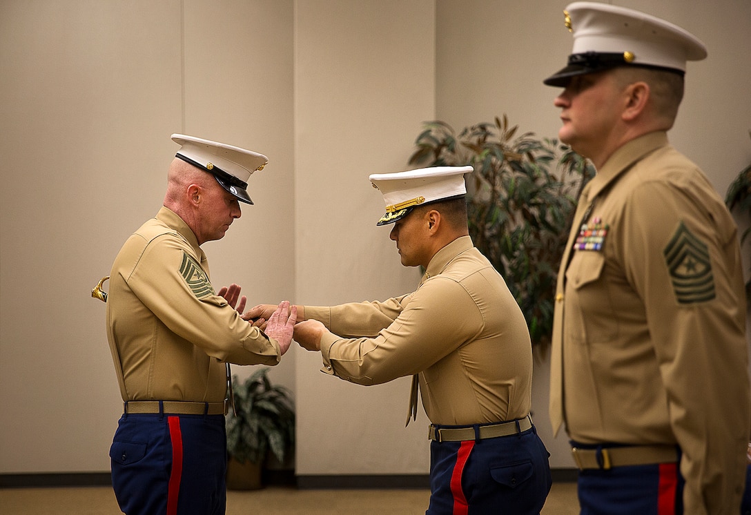 Sgt. Maj. Jeffrey Dagenhart (left), the incoming enlisted leader of Marine Corps Recruiting Station Seattle, receives the sword of office from Maj. Sung Kim, his commanding officer, during a passage of command ceremony in Seattle Dec. 12, 2015. During the ceremony, Sgt. Maj. Kent Cartmill, from Garden City, Kan., was awarded a Meritorious Service Medal and relinquished duties to Dagenhart. (U.S. Marine Corps photo by Sgt. Reece Lodder)