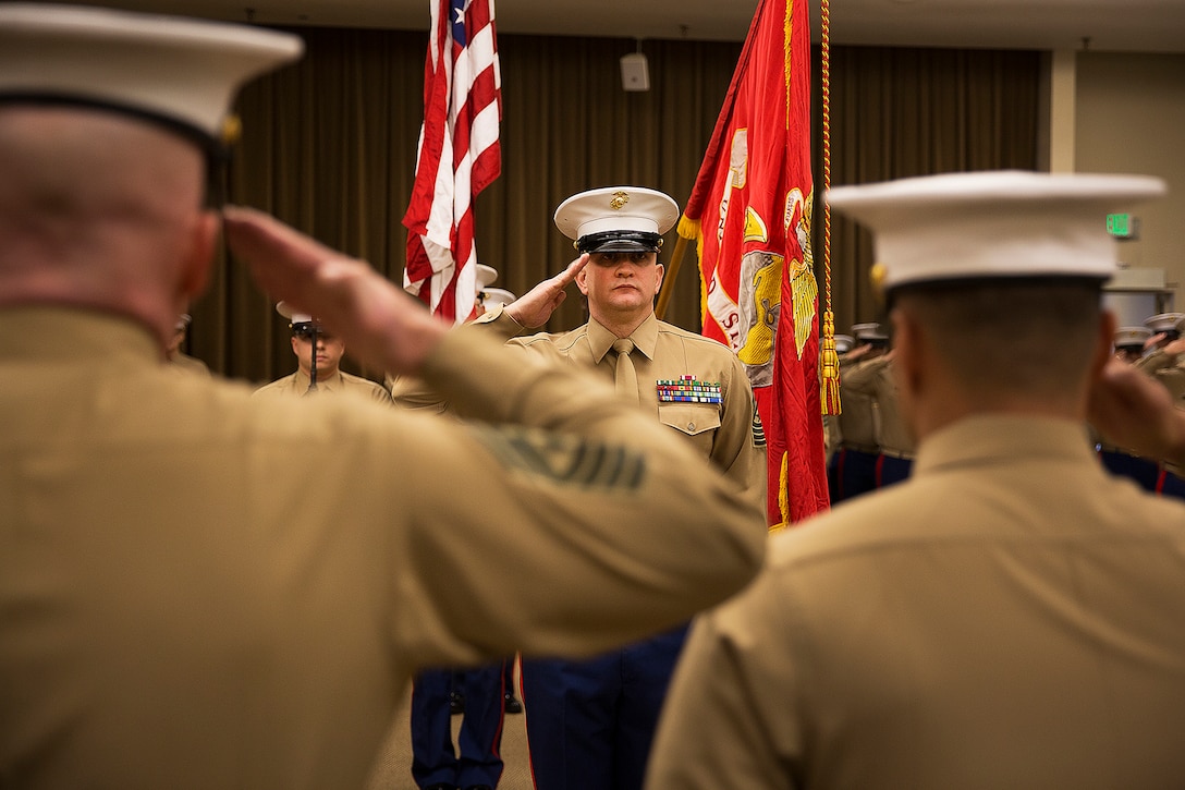 Sgt. Maj. Kent Cartmill (center), the outgoing senior enlisted leader of Marine Corps Recruiting Station Seattle, renders honors to Maj. Sung Kim, the commanding officer, during a passage of command ceremony in Seattle Dec. 12, 2015. During the ceremony, Cartmill, from Garden City, Kan., was awarded a Meritorious Service Medal and relinquished duties to Sgt. Maj. Jeffrey Dagenhart. (U.S. Marine Corps photo by Sgt. Reece Lodder)