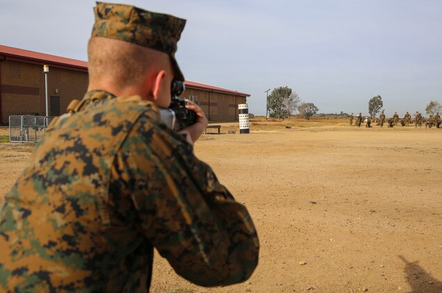 A recruit of Fox Company, 2nd Recruit Training Battalion, sights in on a barrel painted with targets during Grass Week at Edson Range, Weapons and Field Training Battalion, Marine Corps Base Camp Pendleton, Calif., Dec. 9. The barrels have targets painted on them simulating what they will see from the 200, 300 and 500-yard line. Today, all males recruited from west of the Mississippi are trained at MCRD San Diego. The depot is responsible for training more than 16,000 recruits annually. Fox Company is scheduled to graduate Jan. 29.