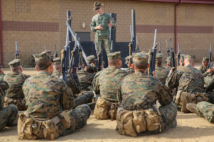 Sergeant David A. Phelps, primary marksmanship instructor, Weapons and Field Training Battalion, teaches recruits about weapons fundamentals during Grass Week at Edson Range, WFTBN, Marine Corps Base Camp Pendleton, Calif., Dec. 9. The recruits participated in classes taught by their PMIs, and they learned more about handling their weapon and what they’ll be doing with it for the weeks to come. Today, all males recruited from west of the Mississippi are trained at MCRD San Diego. The depot is responsible for training more than 16,000 recruits annually. Fox Company is scheduled to graduate Jan. 29. 