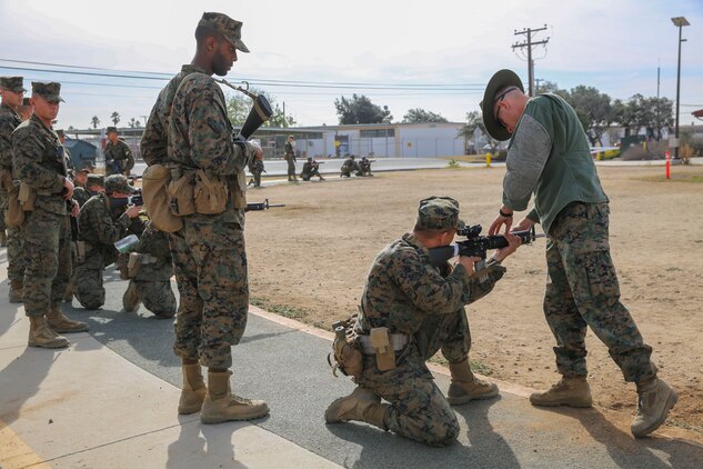 Sergeant David A. Phelps, primary marksmanship instructor, Weapons and Field Training Battalion, helps a recruit with his kneeling position during Grass Week at Edson Range, WFTBN, Marine Corps Base Camp Pendleton, Calif., Dec. 9. The PMIs corrected the recruits’ firing positions to ensure the recruits were comfortable and prepared to conduct live firing the following week. Today, all males recruited from west of the Mississippi are trained at MCRD San Diego. The depot is responsible for training more than 16,000 recruits annually. Fox Company is scheduled to graduate Jan. 29.