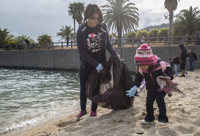 Sgt. Susana Ramirez, a food service specialist with Marine Wing Support Squadron 171, and her daughter Aaliyah, collect debris at Katazoe Beach on Oshima Island, Japan, during the Oshima Beach Cleanup Dec. 12, 2015. Approximately 90 volunteers helped with the cleanup organized by Marine Aircraft Group 12 Chaplain’s office and the Single Marine Program at Marine Corps Air Station Iwakuni.