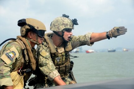 150807-N-FN215-085 SURABAYA, Indonesia (Aug. 7, 2015) Boatswain's Mate 1st Class Kevin Diebold, right, assigned to Coastal Riverine Squadron (CRS) 3, communicates with an Indonesian “Kopaska” Naval Special Forces team leader while practicing interdiction techniques during Cooperation Afloat Readiness and Training (CARAT) Indonesia 2015. In its 21st year, CARAT is an annual, bilateral exercise series with the U.S. Navy, U.S. Marine Corps and the armed forces of nine partner nations. (U.S. Navy photo by Mass Communication Specialist 1st Class Joshua Scott/Released)
