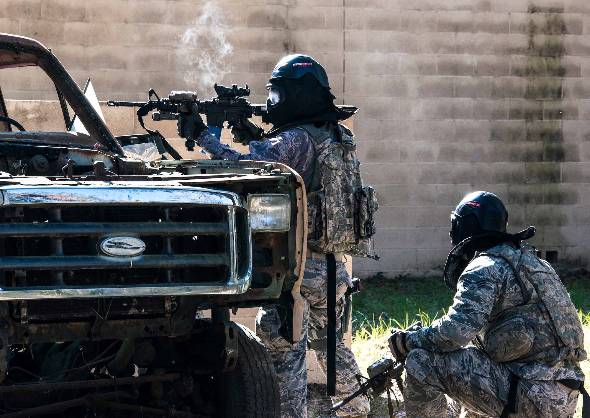 An Airman from the 822d Base Defense Squadron, fires at the enemy team while his teammate takes cover during force-on-force training, Dec. 10, 2015, at Moody Air Force Base, Ga. During the training, Airmen used M4 carbine rifles and M9 Beretta pistols filled with simulation rounds. (U.S. Air Force photo by Airman 1st Class Lauren M. Johnson/Released)