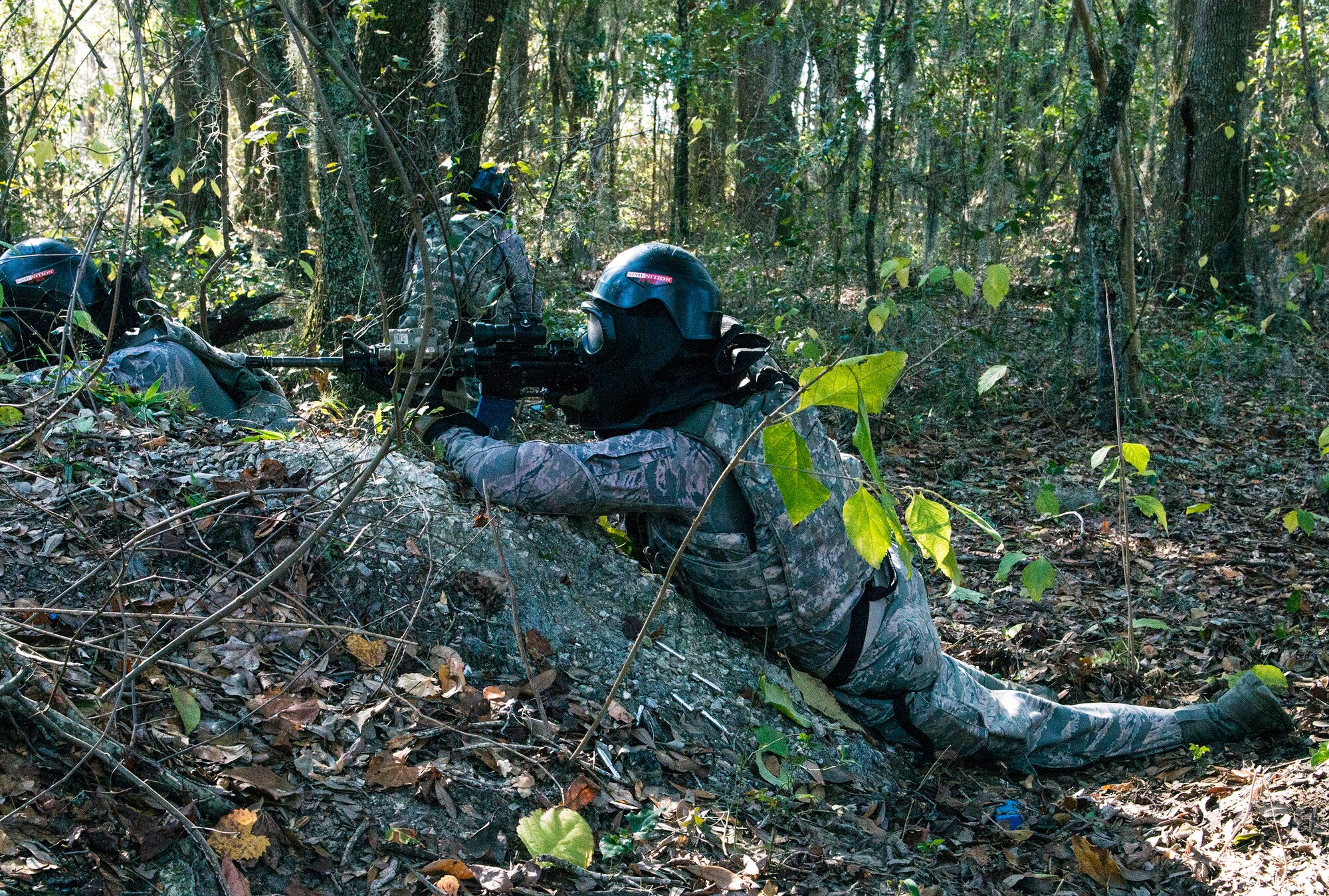 U.S. Air Force Senior Airman Zachary Grimm, 822d Base Defense Squadron fire team member, fires at enemy forces while maintaining cover during force-on-force training, Dec. 10, 2015, at Moody Air Force Base, Ga. The Airmen participated in the quarterly training to stay qualified on their weapons. (U.S. Air Force photo by Airman 1st Class Lauren M. Johnson/Released)