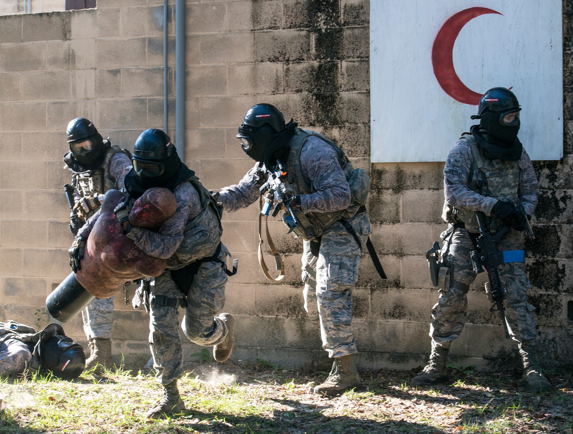 An Airman from the 822d Base Defense Squadron, rescues a simulated casualty while teammates provide cover during force-on-force training, Dec. 10, 2015, at Moody Air Force Base, Ga. For the exercise, Airmen were split into two teams and tasked to recover and protect a casualty while opposing forces attempted to infiltrate. (U.S. Air Force photo by Airman 1st Class Lauren M. Johnson/Released)