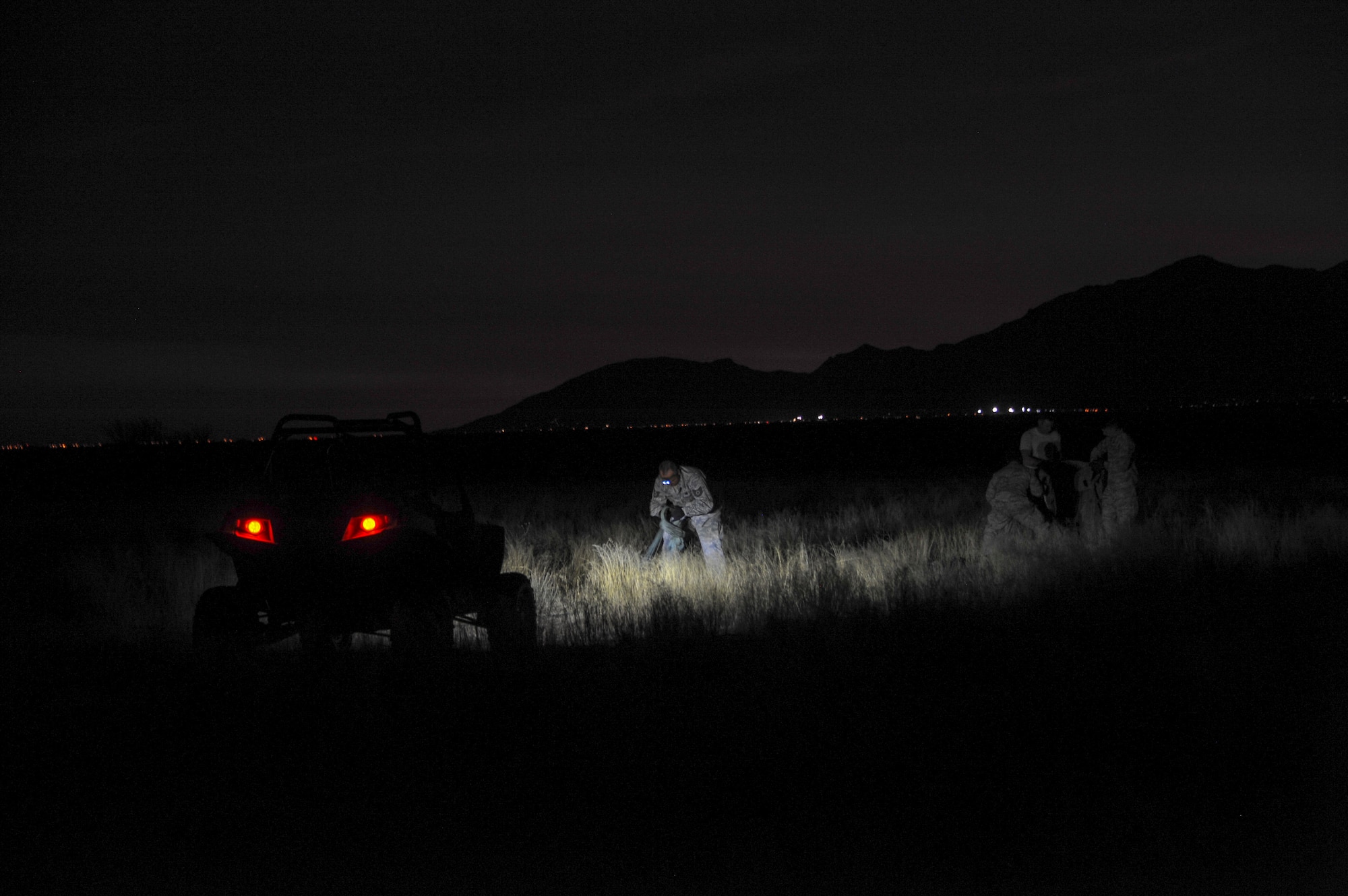 U.S. Airmen from the 563rd Operations Support Squadron fold a parachute during aerial delivery and recovery training at Fort Huachuca, Ariz., Dec. 9, 2015. This training was the first time any rescue operations support squadron packaged and rigged a heavy vehicle without external assistance and the first time a heavy vehicle was dropped by the 79th Rescue Squadron. (U.S. Air Force photo by Senior Airman Chris Massey/Released)