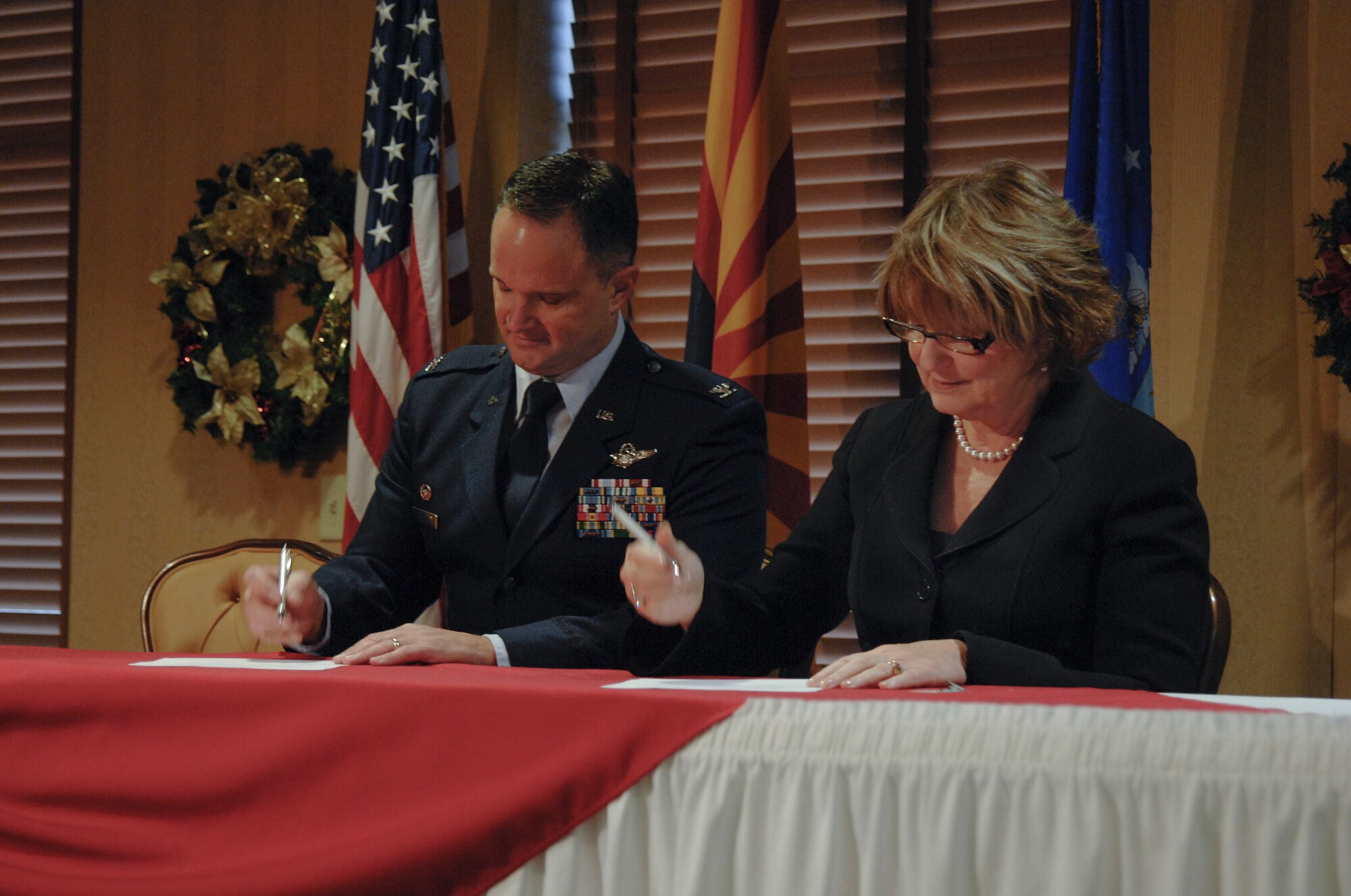 U.S. Air Force Col. Ryan Rogers, 55th Electronic Combat Group commander, and Ann Weaver Hart, University of Arizona president, sign the Foreign Language Skills Partnership memorandum of understanding at Davis-Monthan Air Force Base, Ariz., Dec. 14, 2015. The Foreign Language Skills Partnership will improve and maintain the existing Foreign Language Skills project and mentor foreign language students with the University of Arizona. (U.S. Air Force photo by Staff Sgt. Angela Ruiz/Released)