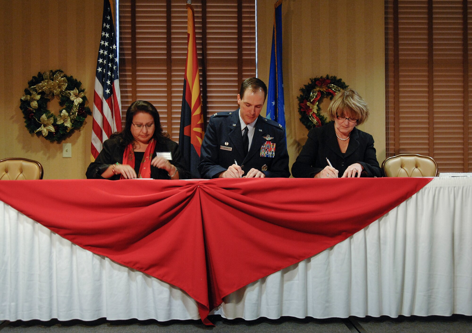 Dr. Dolores Duran-Cerda, Pima Community College academic and student services provost and executive vice chancellor, U.S. Air Force Col. James Meger, 355th Fighter Wing commander and Ann Weaver Hart, University of Arizona president, sign the Educational Partnership memorandum of understanding at Davis-Monthan Air Force Base, Ariz., Dec 14, 2015. The Educational Partnership agreement will establish on-base internship opportunities for students of the University of Arizona and Pima Community College. (U.S. Air Force photo by Staff Sgt. Angela Ruiz/Released)