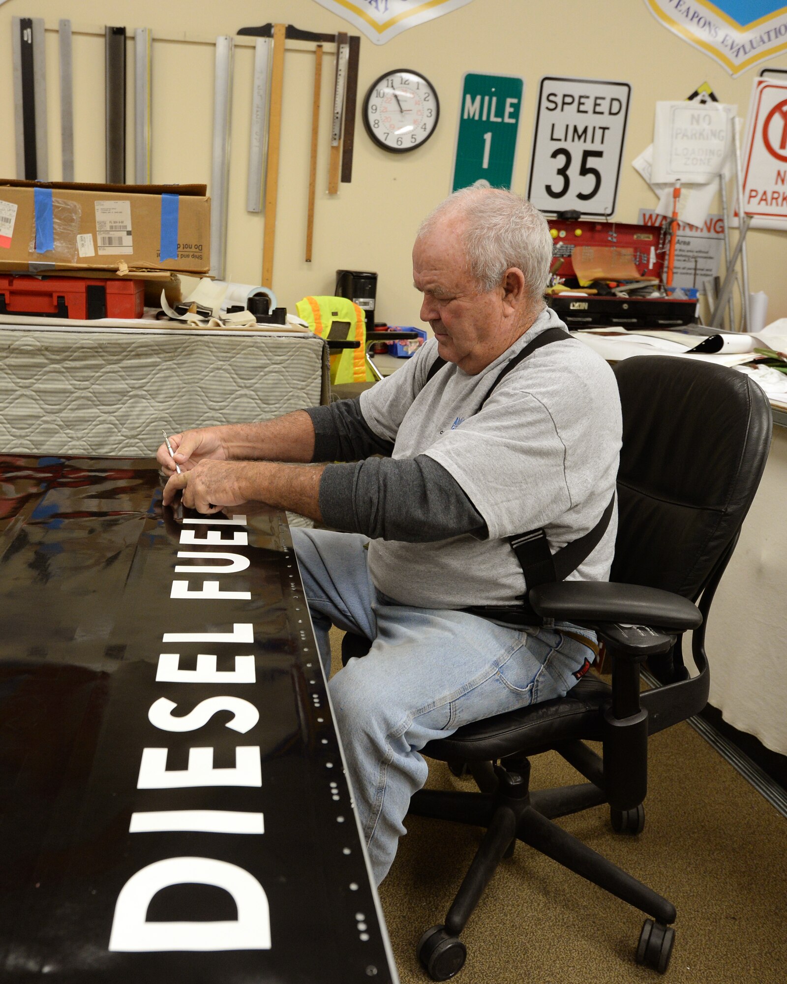 Bob Mallory, 325th Civil Engineering Squadron sign manufacturer, cuts out the letters on a fuel tank sign.  Mallory creates all the signs that are seen across Tyndall.  The contractors that support the 325th CES play a vital role in keeping up the infrastructure of Tyndall AFB.  (U.S. Air Force photo by Airman 1st Class Cody R. Miller/Released) 