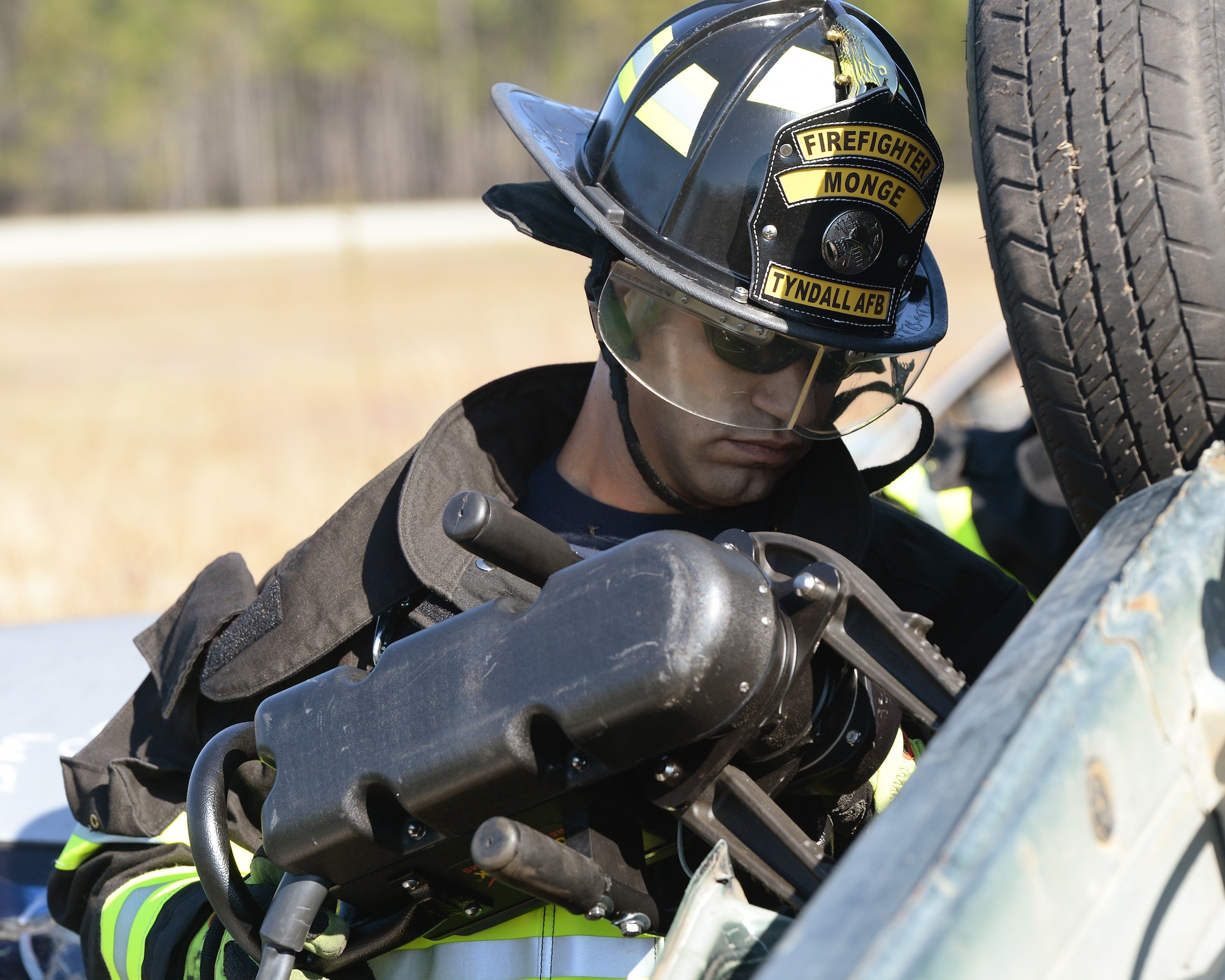 Edward Monge, 325th Civil Engineering Squadron firefighter, uses the jaws-of-life to pry open a crashed car door during a vehicle extrication exercise.  The firefighters of the 325th CES ensure the safety of all of Tyndall’s service members, civilians, and contractors. (U.S. Air Force photo by Airman 1st Class Cody R. Miller/Released)