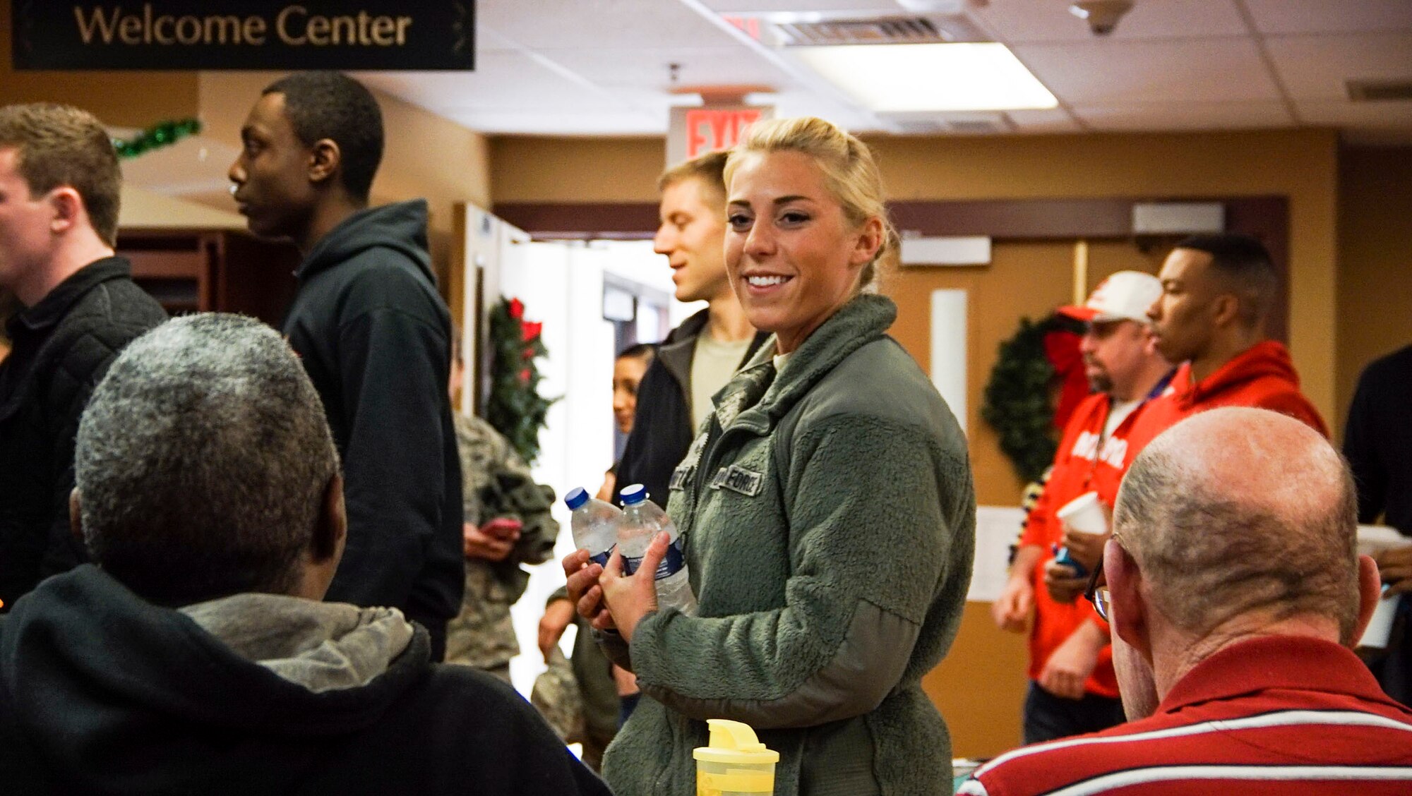 DAYTON, Ohio - Senior Airman Cecilia Photinos, 445th Operations Support Squadron aircrew flight equipment journeyman, hands out water to veterans during a meal at Lakeside Manor at Dayton Veterans Affairs Medical Center, Dayton, Ohio on Dec. 5, 2015. Military and non-military volunteers supported the annual VA holiday party by handing out food and spending time with the veterans. (U.S. Air Force photo/Senior Airman Devin Long)
