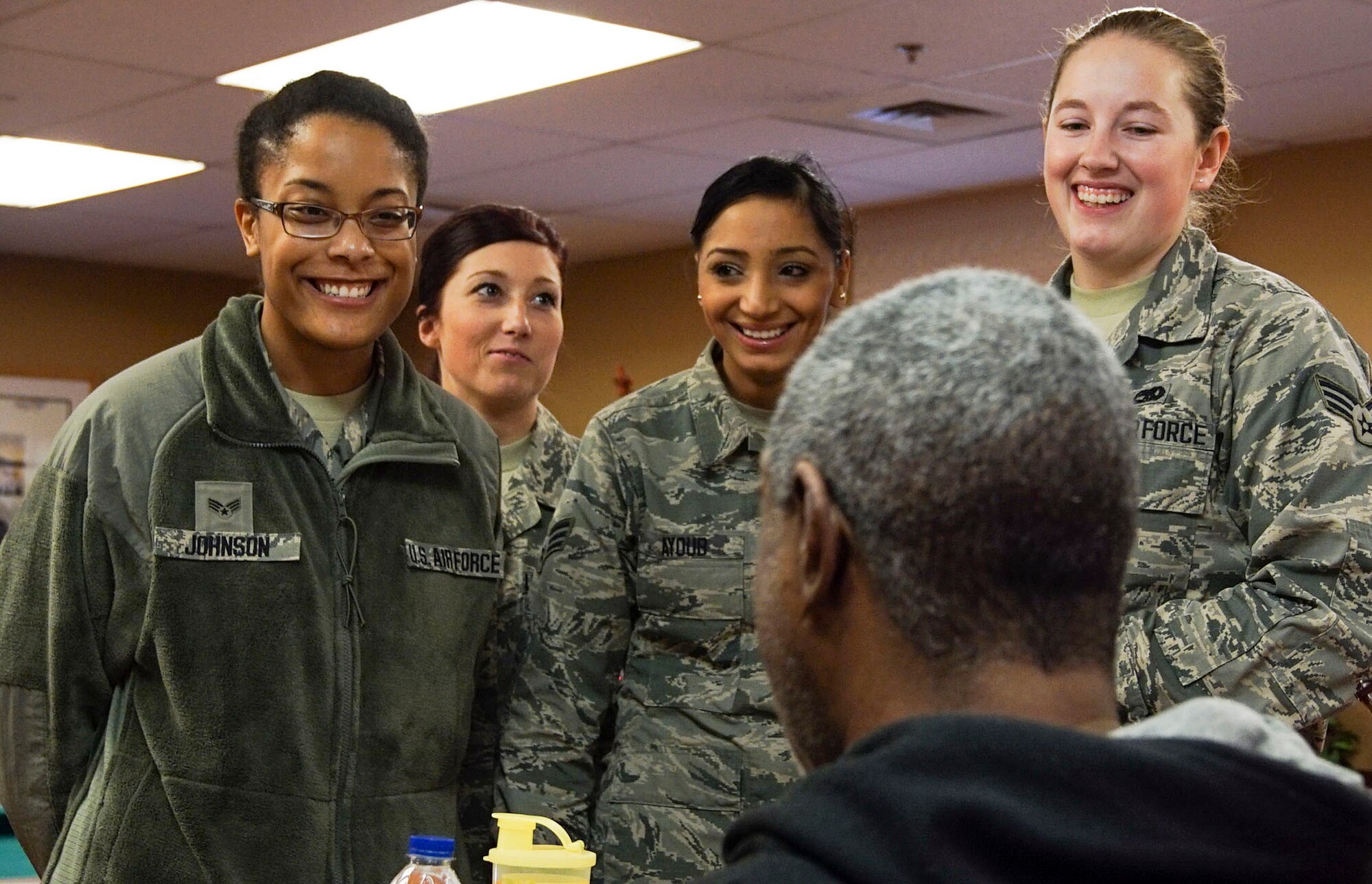 DAYTON, Ohio - Senior Airman Unity Johnson, Airman 1st Class Samantha Johnson, Senior Airman Jowanda Ayoud and Senior Airman Nicole Patterson, maintenance schedulers with the 445th Maintenance Group, talk with veterans during the annual Dayton holiday party at Lakeside Manor, Dayton Veterans Affairs Medical Center Dec. 5, 2015. The party included volunteers serving food to the members, music, and a visit from Santa.. (U.S. Air Force photo/Senior Airman Devin Long)
