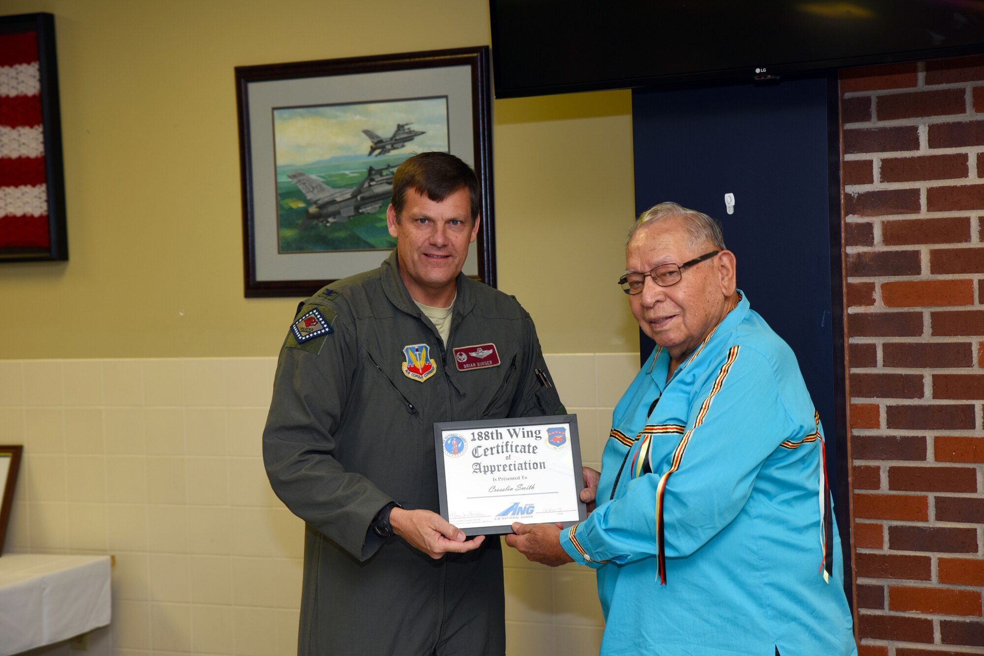 Crosslin Smith, Cherokee Nation spiritual resource person, receives a certificate of appreciation from Col. Brian Burger, 188th Operations Group commander, at Ebbing Air National Guard Base, Fort Smith, Ark., for Native American Indian Heritage Month to members of the 188th Wing Nov. 18, 2015. Smith represented the Cherokee Nation during the Korean War as a member of the 45th Thunderbird Division and is a member of the Keetoowah Society. (U.S. Air National Guard photo by Senior Airman Cody Martin/Released)