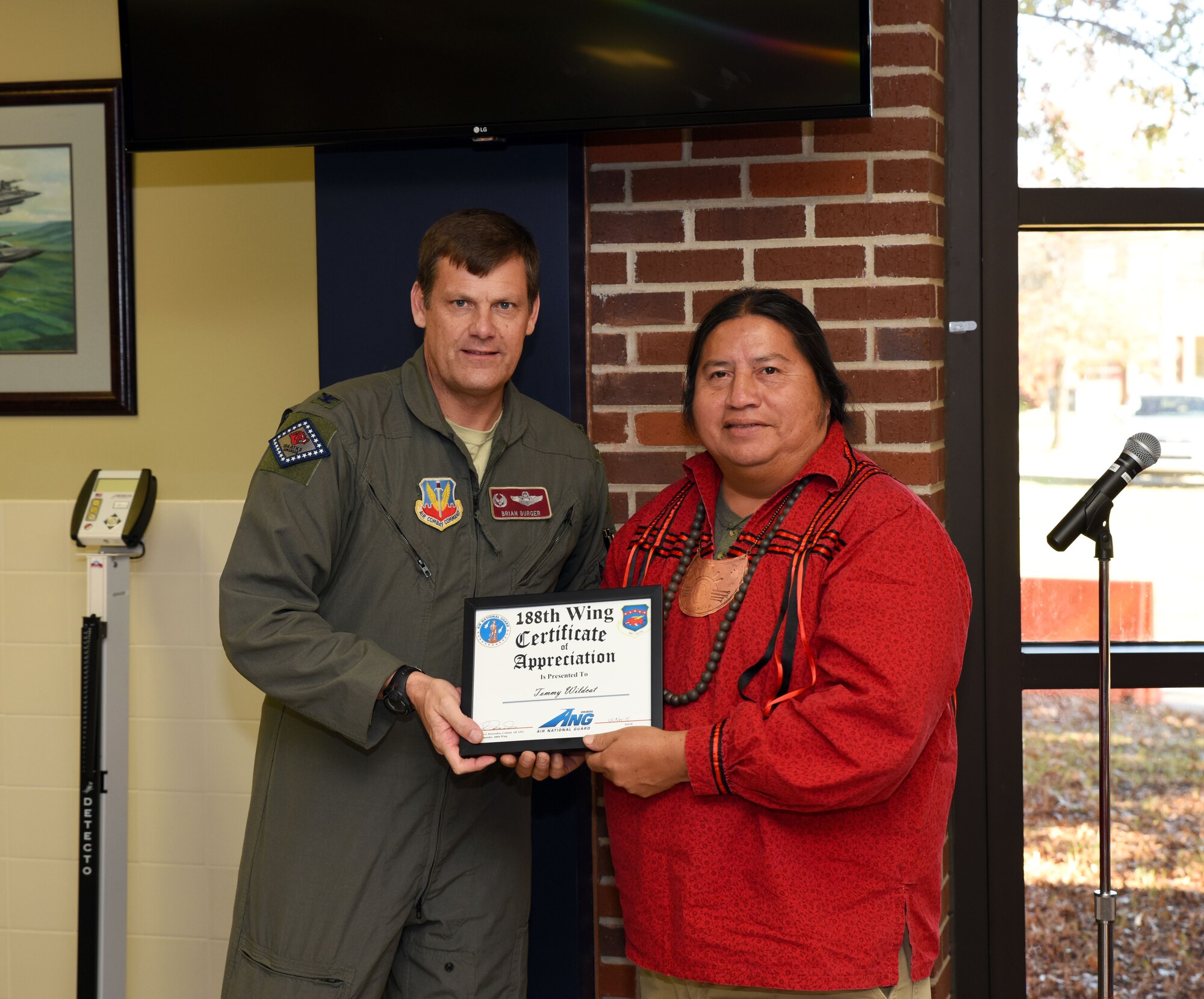 Tommy Wildcat, supervisor of the Ancient Village living history exhibit and accomplished Cherokee recording artist, receives a certificate of appreciation from Col. Brian Burger, 188th Operations Group commander, at Ebbing Air National Guard Base, Fort Smith, Ark., for his participation in the 188th Wing’s Native American Indian Heritage Month celebration Nov. 18, 2015. Wildcat has been featured in soundtracks that range from Discovery Channel’s “How the West was Lost” to Turner Network Television’s movie “Tecumseh, the Last Warrior.” (U.S. Air National Guard photo by Senior Airman Cody Martin/Released)