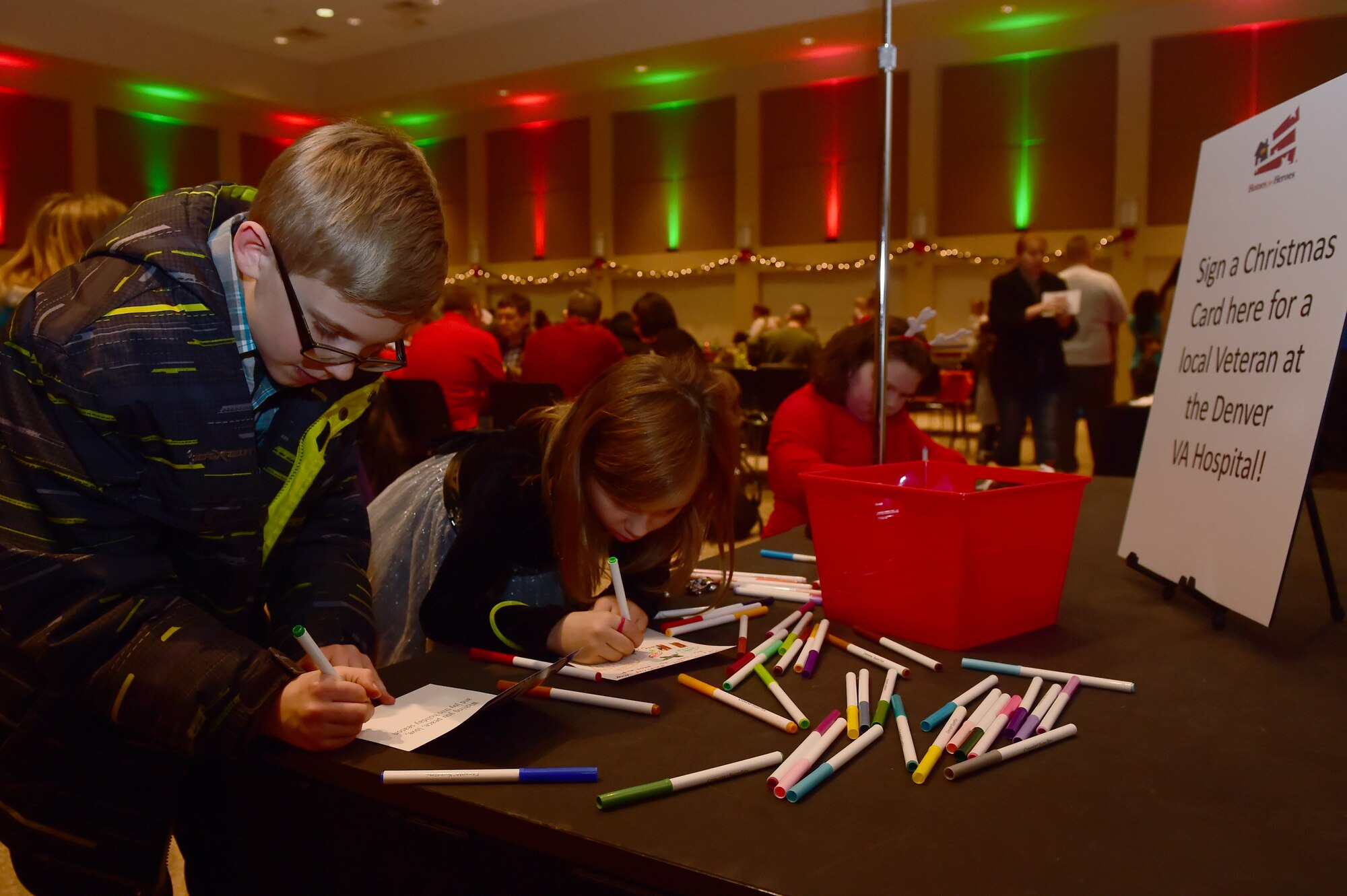 Team Buckley youth write Christmas cards for veterans at the Denver VA Hospital during Breakfast with Santa at the Leadership Development Center Dec. 12, 2015, on Buckley Air Force Base, Colo. The event provided breakfast, a gift for each child and the opportunity for a picture with Santa Claus. (U.S. Air Force photo by Airman 1st Class Luke Nowakowski/Released)