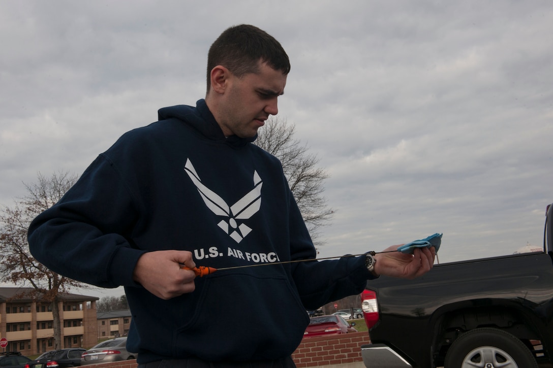 Airman 1st Class Sergei Custis, 11th Logistics Readiness Squadron vehicle maintenance apprentice, checks the oil during a free winter vehicle inspection event at Joint Base Andrews, M.d., Dec. 12, 2015. Airmen from the 11th Logistics Readiness Squadron Vehicle Management Flight performed the inspections that included checking the tire pressure and tire wear, fluids, lights, windshield wipers and the serpentine belt condition. (U.S. Air Force photo by Senior Airman Dylan Nuckolls/Released)