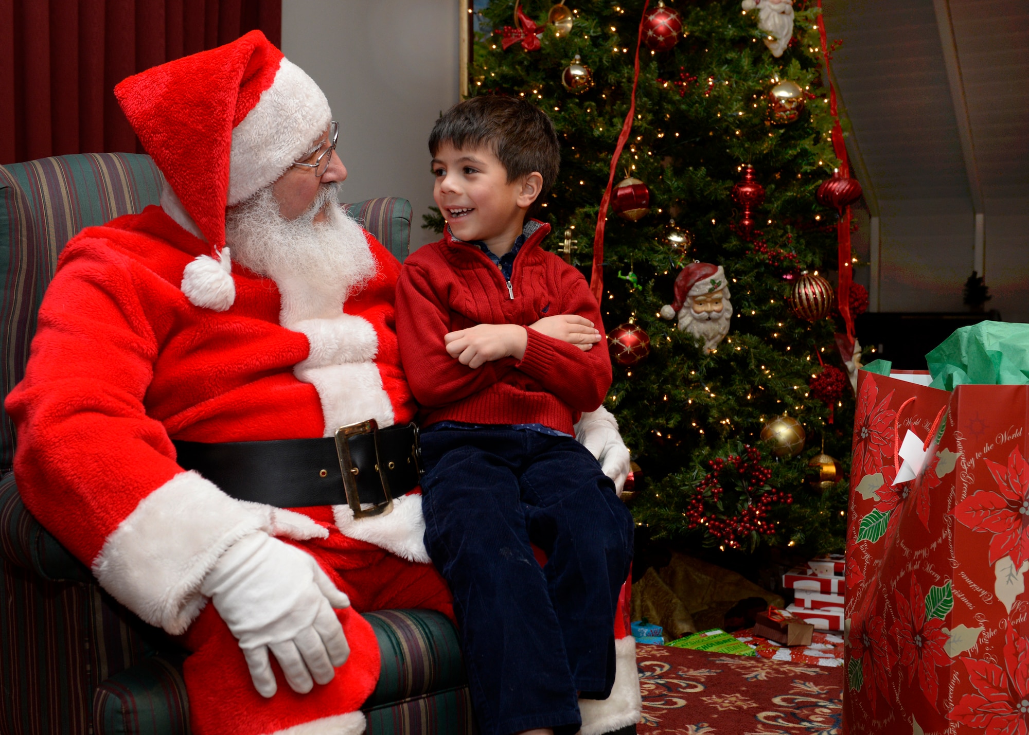 Santa Claus speaks with Leeland Hertzler, age 5, at the monthly Hearts Apart event, hosted by the Airman and Family Readiness Center, at the Minuteman Commons Dec. 17. Families of deployed military personnel were treated to an evening of holiday fun and pizza. (U.S. Air Force photo by Mark Wyatt)