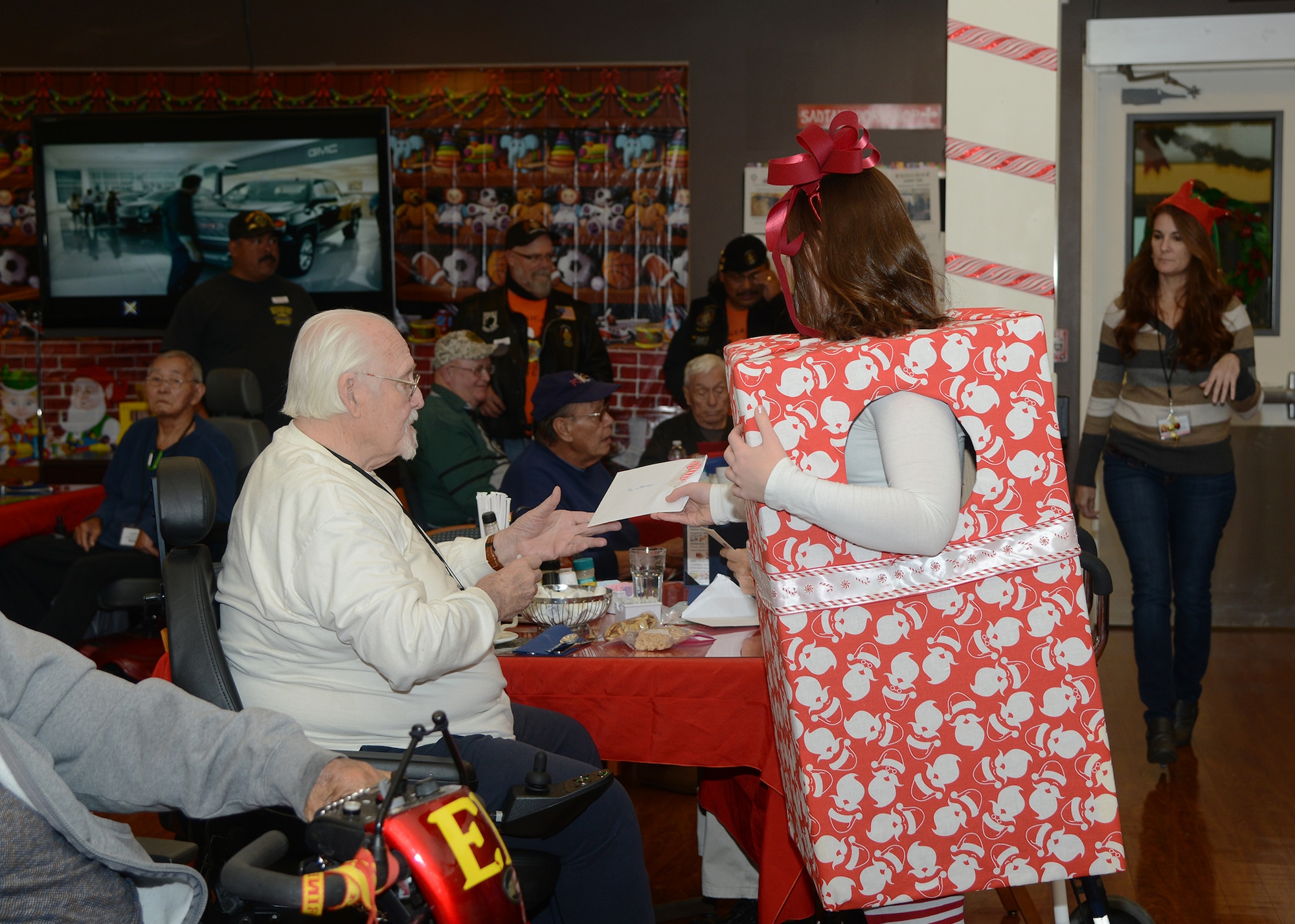 Senior Airman Alexis Tripodi, 412th Force Support Squadron, gives a holiday card to a resident at the William J. Pete Knight Veteran’s Home in Lancaster, California. (U.S. Air Force photo by Rebecca Amber)