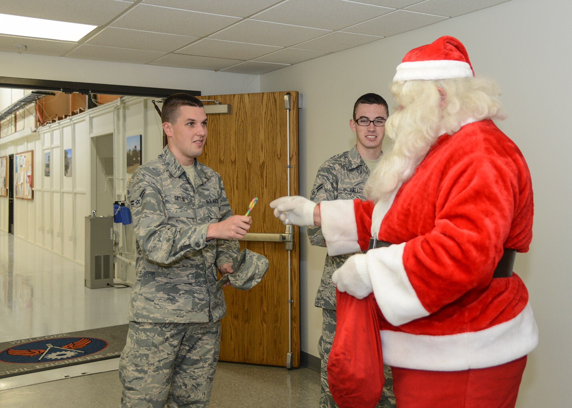 Santa Claus hands candy canes to Airmen at 412th Civil Engineering Group. (U.S. Air Force photo by Rebecca Amber)