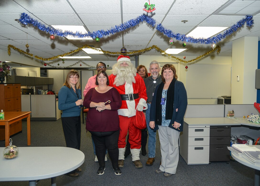 Santa Claus poses for a photo with 412th Civil Engineering Group employees. (U.S. Air Force photo by Rebecca Amber)