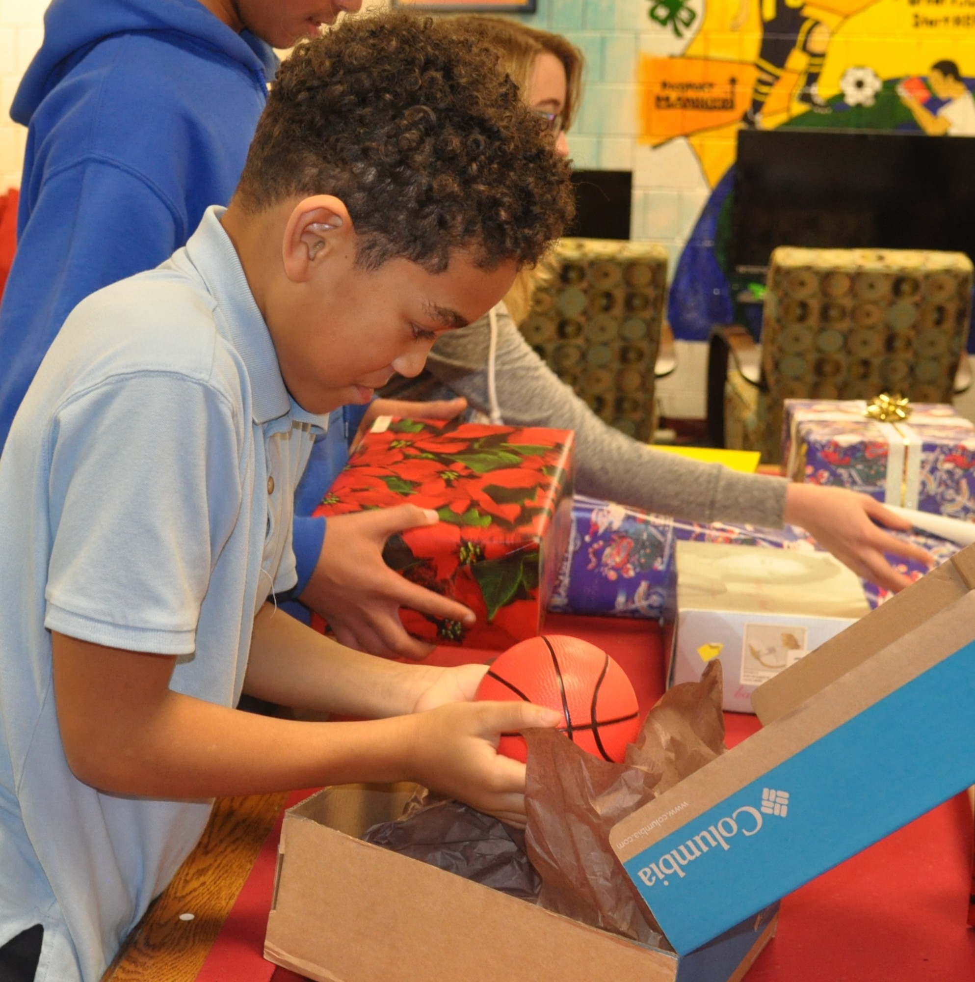 Prairies Youth Center member Julian Smith-Custer stuffs shoeboxes with toys as other members wrap them. The members delivered the shoeboxes to the children at Montgomery County Child Services Dec. 17. (U.S. Air Force photo/Myra Saxon)