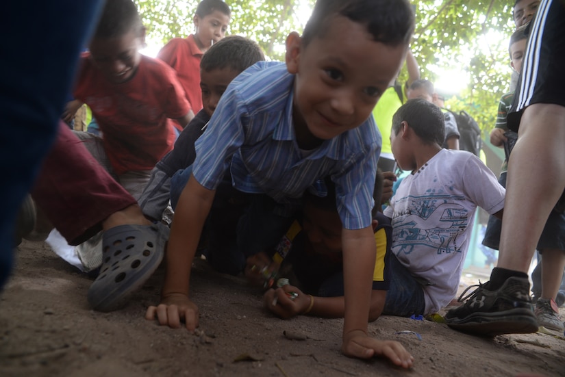 A Honduran boy grabs candy that fell from a piñata during Chapel Hike 65, Honduras, Dec. 12, 2015. Chapel hikes like this one help build bonds with local communities. (U.S. Air Force photo by Senior Airman Westin Warburton/Released)