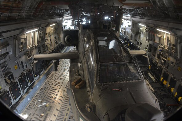 One of two Apache helicopters from Fort Bliss, Texas sits in the back of a C-17 Globemaster III at Al Udeid Air Base, Qatar Dec. 13. The C-17, which is deployed from the 62nd Airlift Wing at Joint Base Lewis-McChord, Washington, delivered the helicopters. The helicopters are scheduled to take part in the annual Qatar National Day Parade set for Dec. 18. (U.S. Air Force photo by Tech. Sgt. James Hodgman/Released)