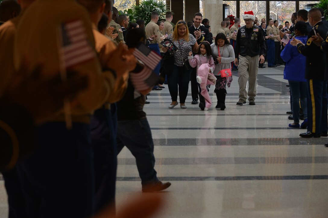 Gold Star families walk between a line of U.S. Service members at Norfolk International Airport in Norfolk, Va., Dec. 12, 2015. The military members cheered for the families of fallen Service members as they departed for the 9th annual Snowball Express, which brings Gold Star families together for an all-inclusive vacation to Dallas. (U.S. Air Force photo by Staff Sgt. Natasha Stannard)