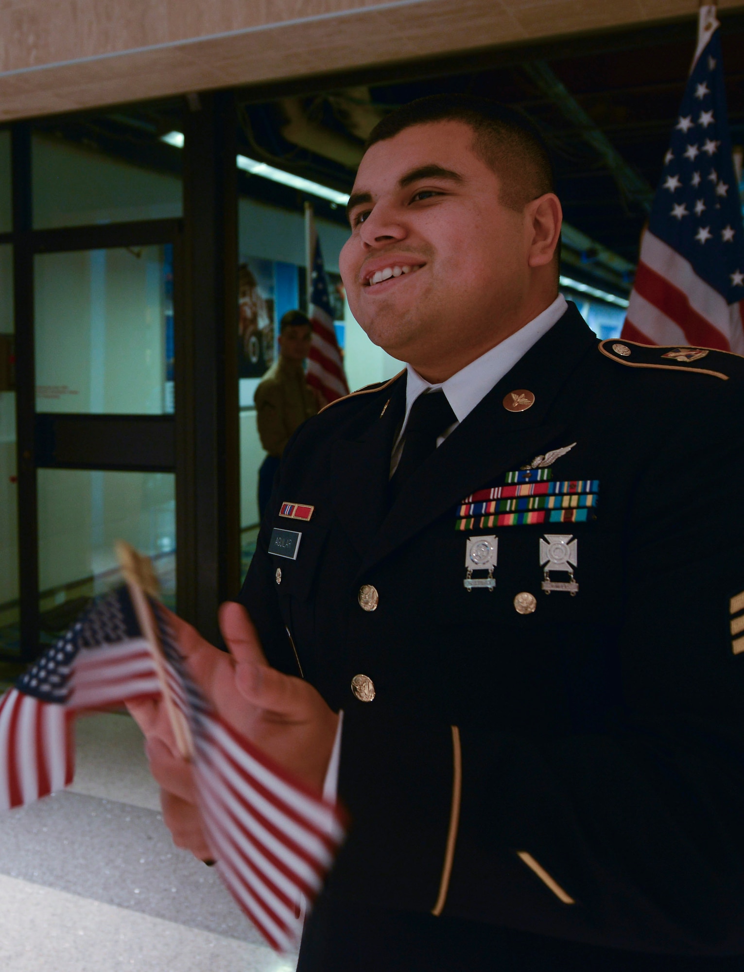 U.S. Army Staff Sgt. Ruben Aguilar, a student at the Joint Base Langley-Eustis (JBLE) Aviation Logistics Noncommissioned Officer Academy, cheers for Gold Star families participating in the Snowball Express at Norfolk International Airport in Norfolk, Virginia, Dec. 12, 2015. U.S. Soldiers and Airmen from JBLE volunteered alongside Service members from across the tidewater region to show support for Gold Star families, families of fallen military members. (U.S. Air Force photo by Staff Sgt. Natasha Stannard)