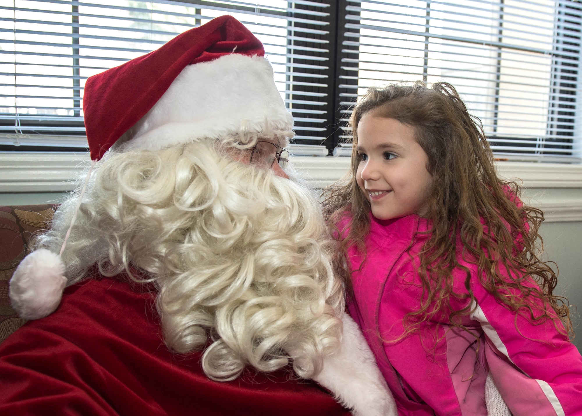 Giuliana Cook visits with Santa Claus during a Santa's Workshop event hosted by the base housing office at the Community Center Dec. 16. The event was held for housing residents and their families and included crafts for children, snacks, a visit from Santa and more. (U.S. Air Force photo by Jerry Saslav)